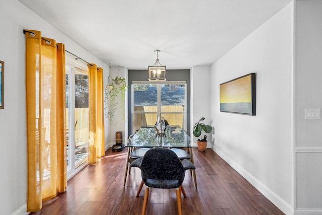 dining room with dark wood-style floors, baseboards, and a chandelier