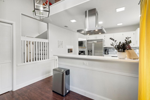 kitchen featuring stainless steel fridge, dark wood-style floors, island exhaust hood, light countertops, and white cabinetry