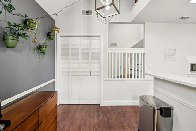 interior space featuring dark wood-type flooring, visible vents, and baseboards