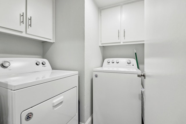 washroom with cabinet space and washer and clothes dryer