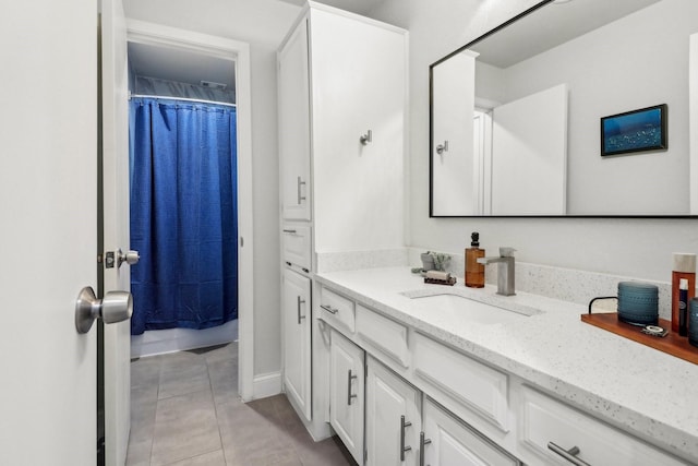 full bath featuring tile patterned floors, baseboards, curtained shower, and vanity