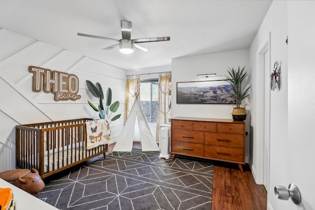 bedroom with a ceiling fan and a nursery area