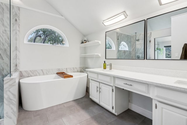 full bath featuring a marble finish shower, double vanity, lofted ceiling, a sink, and a freestanding tub