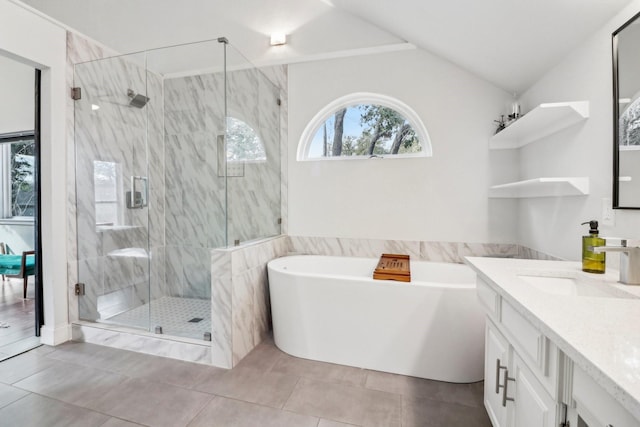 full bathroom with a healthy amount of sunlight, a stall shower, vaulted ceiling, and a freestanding bath