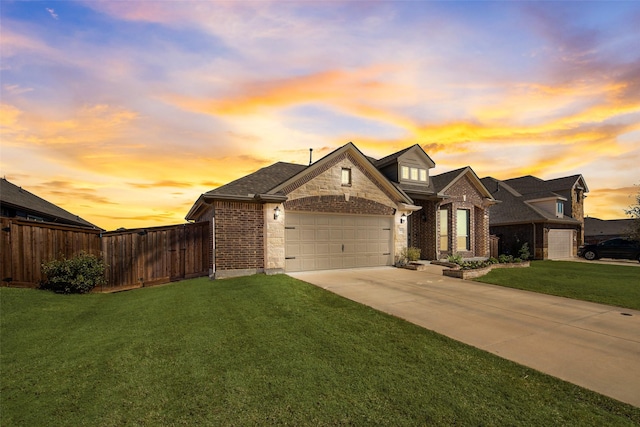 view of front of home featuring an attached garage, fence, concrete driveway, and a yard