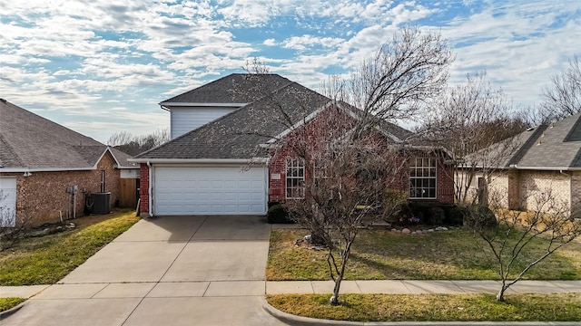 traditional-style house featuring central air condition unit, driveway, an attached garage, a shingled roof, and brick siding