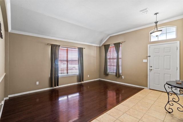 entryway featuring a wealth of natural light, lofted ceiling, wood finished floors, and crown molding