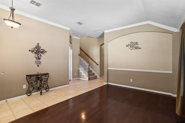 entryway with visible vents, wood finished floors, crown molding, and stairway