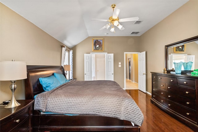 bedroom with visible vents, ceiling fan, dark wood-style flooring, and vaulted ceiling