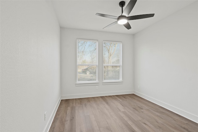 unfurnished room featuring a ceiling fan, baseboards, and wood finished floors