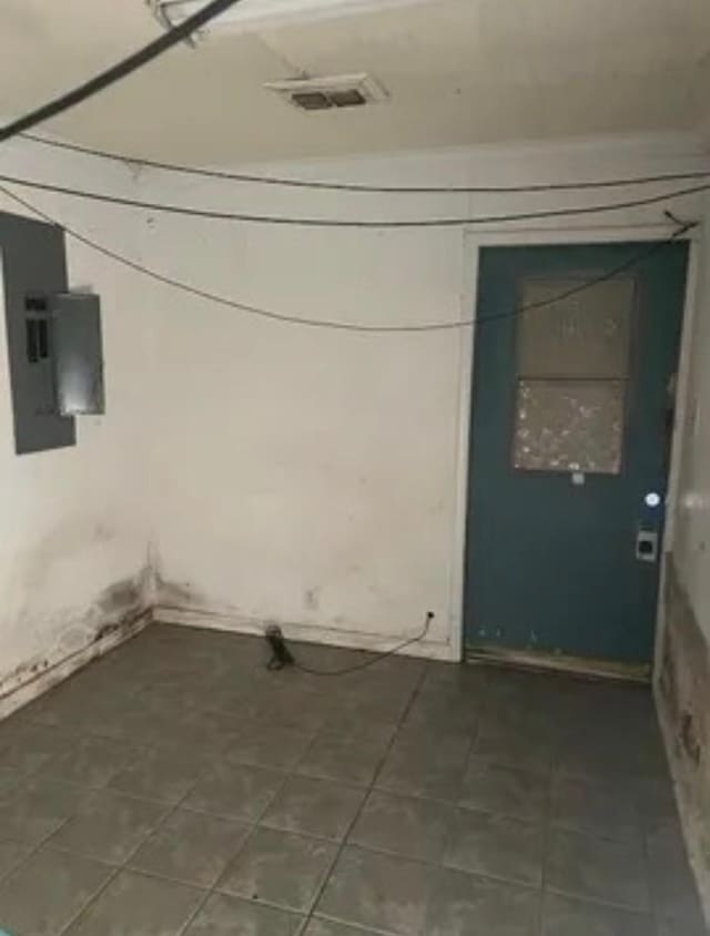 laundry area with electric panel, visible vents, and tile patterned floors