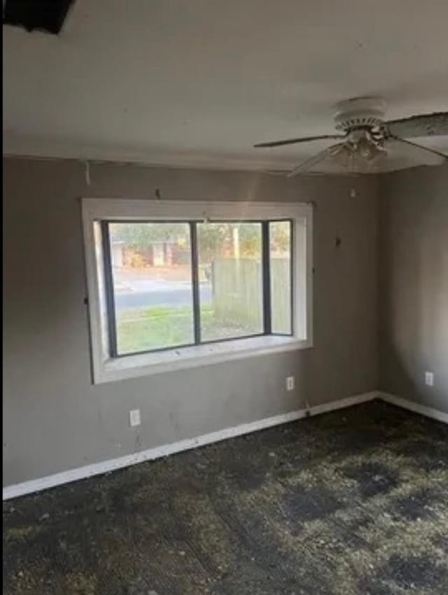 empty room with baseboards and a ceiling fan