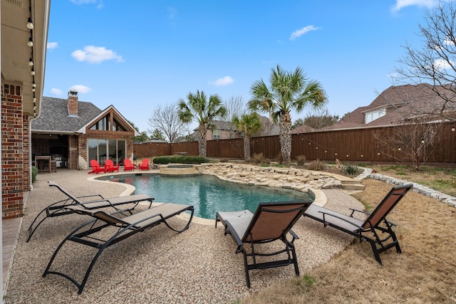 view of swimming pool with a fenced backyard, a pool with connected hot tub, and a patio