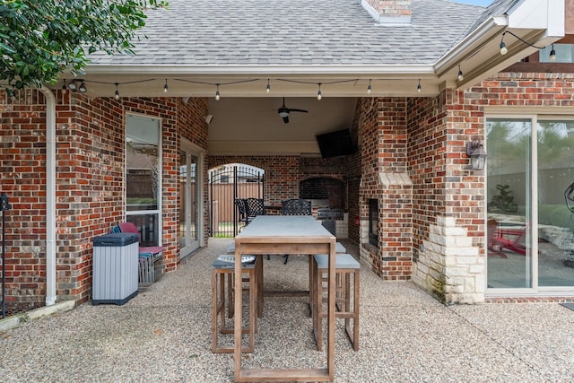 view of patio / terrace with exterior fireplace and a ceiling fan