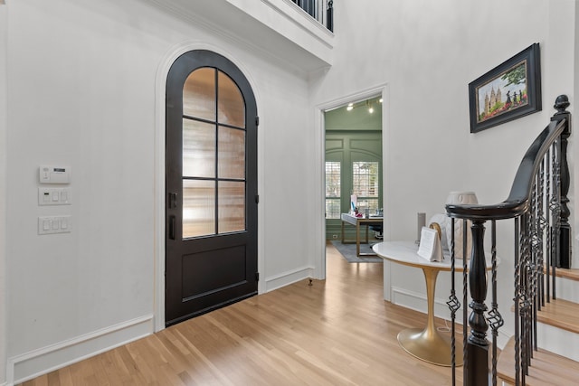 entrance foyer featuring stairs, wood finished floors, and baseboards