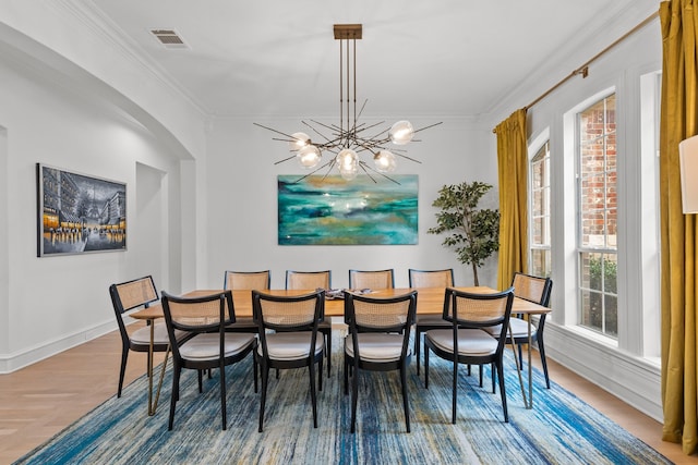 dining space with ornamental molding, wood finished floors, visible vents, and an inviting chandelier