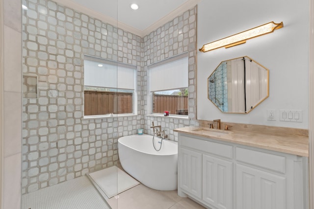 full bath featuring tile walls, a soaking tub, ornamental molding, vanity, and tile patterned floors