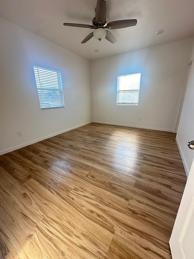 unfurnished room featuring a ceiling fan, baseboards, and wood finished floors