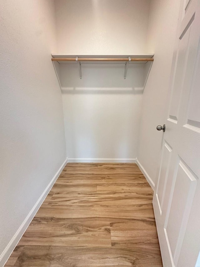 walk in closet with wood finished floors