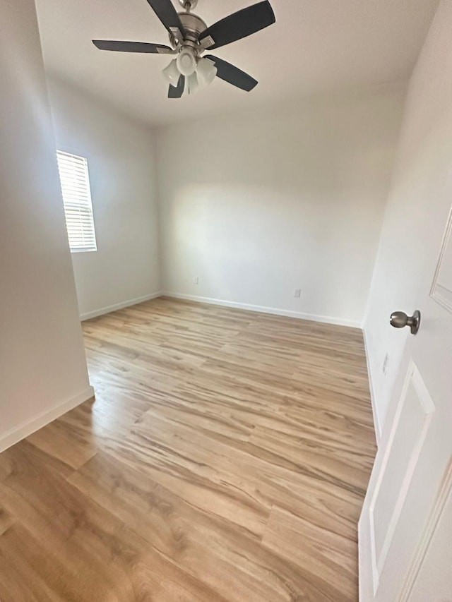 empty room with light wood-style flooring, baseboards, and ceiling fan