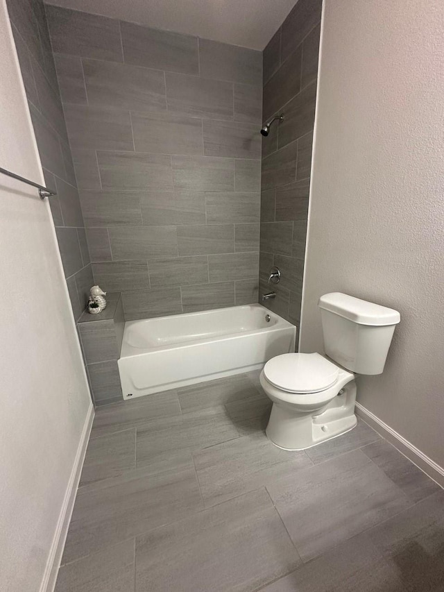 full bathroom featuring baseboards, shower / bath combination, and toilet