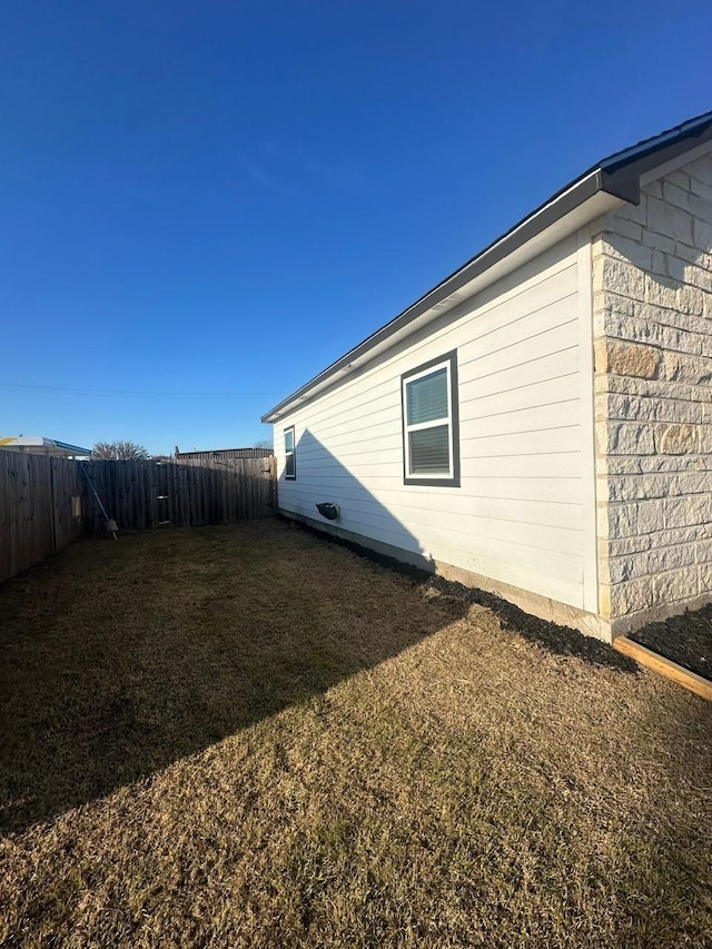 view of home's exterior with a fenced backyard and a lawn