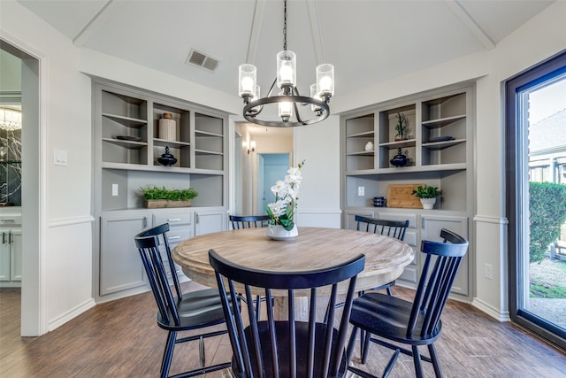 dining space with vaulted ceiling, dark wood-style flooring, a chandelier, and visible vents