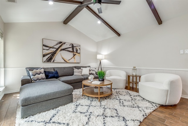 living area featuring visible vents, lofted ceiling with beams, a wainscoted wall, ceiling fan, and wood finished floors