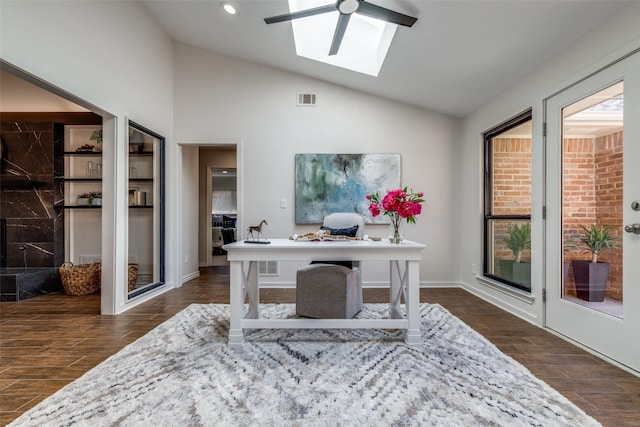 office with lofted ceiling with skylight, wood tiled floor, visible vents, and ceiling fan