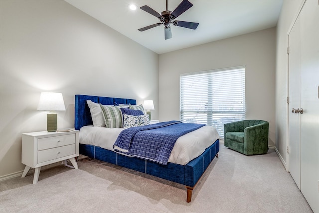 bedroom with ceiling fan, baseboards, and light colored carpet