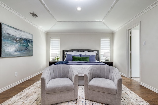 bedroom with crown molding, visible vents, vaulted ceiling, wood finished floors, and baseboards