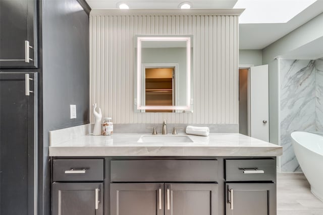 full bath with a soaking tub and vanity