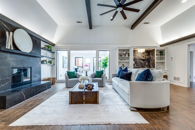 living area with visible vents, beamed ceiling, and a high end fireplace