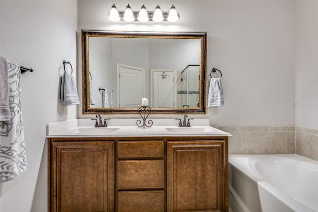 full bathroom featuring a bath, a shower stall, double vanity, and a sink