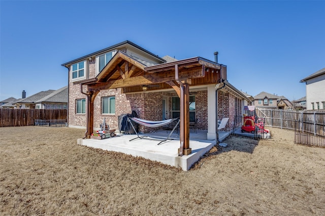 rear view of property with a patio area, brick siding, and a fenced backyard