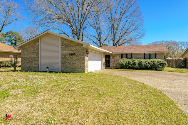 view of front of home featuring an attached garage, concrete driveway, brick siding, and a front yard