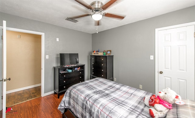 bedroom featuring a ceiling fan, baseboards, visible vents, and wood finished floors