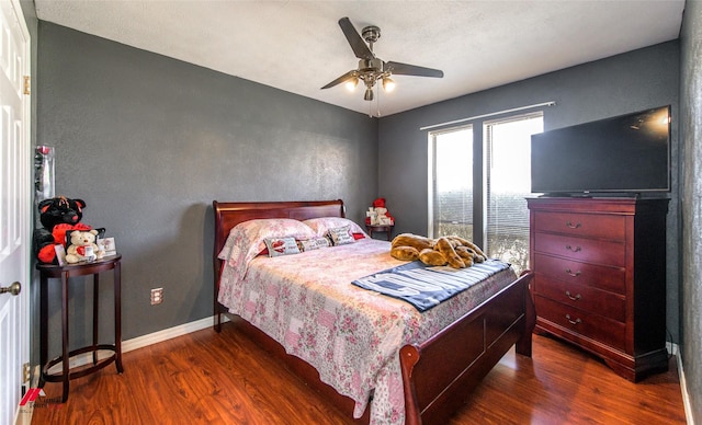 bedroom with dark wood-style floors, ceiling fan, and baseboards