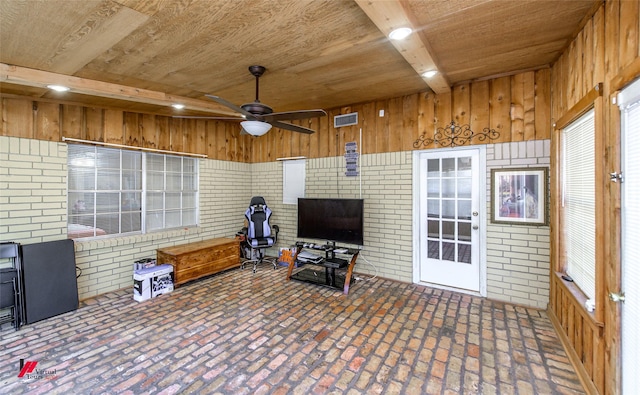 sunroom featuring wood ceiling, visible vents, ceiling fan, and beam ceiling