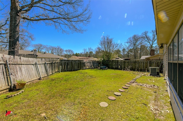 view of yard with central AC unit and a fenced backyard