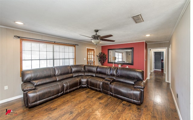 living room featuring crown molding, wood finished floors, visible vents, and baseboards