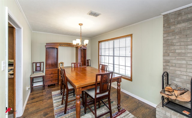 dining room with ornamental molding, visible vents, dark wood finished floors, and an inviting chandelier