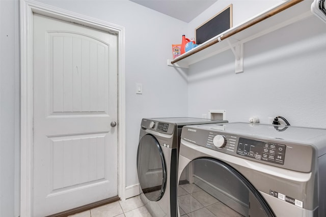 washroom with laundry area, light tile patterned floors, and separate washer and dryer