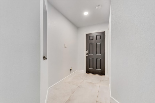 doorway to outside featuring light tile patterned floors and baseboards