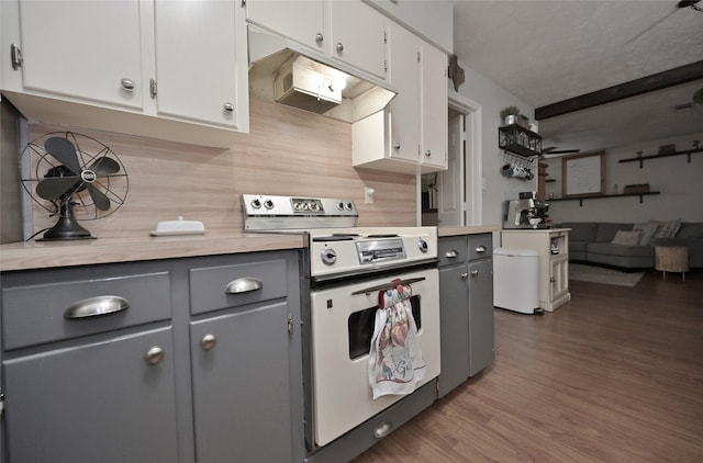 kitchen featuring light countertops, wood finished floors, stove, and gray cabinets