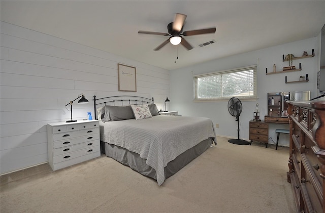 bedroom with a ceiling fan, visible vents, and light colored carpet