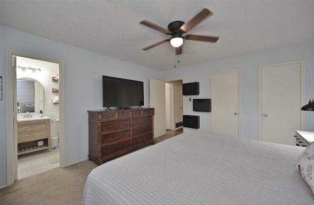 carpeted bedroom featuring a ceiling fan, connected bathroom, and a sink