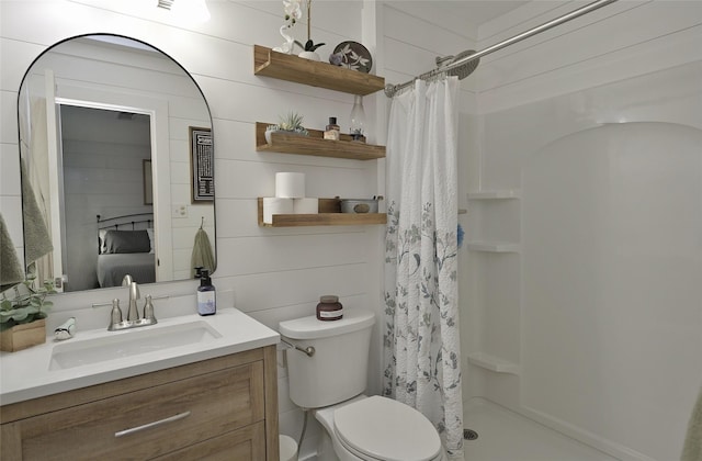 bathroom featuring toilet, a shower stall, and vanity