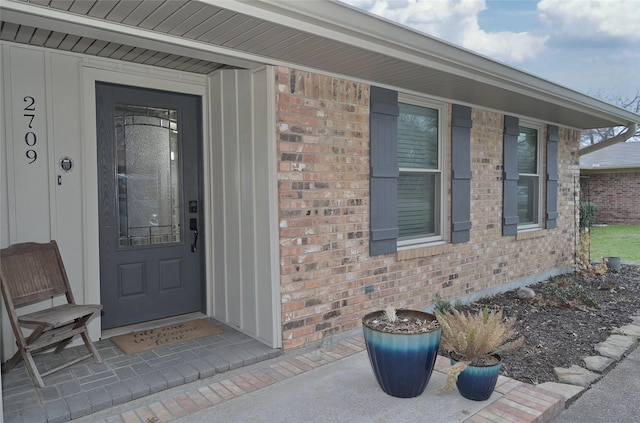 view of exterior entry featuring brick siding