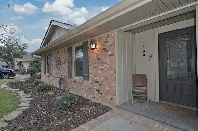 entrance to property featuring brick siding